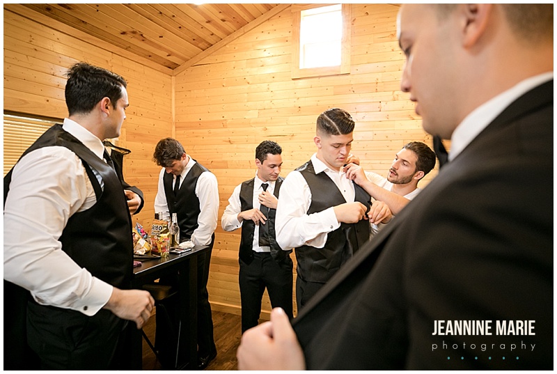 groom, groomsmen, getting ready, putting on clothes, The Gardens of Castle Rock, outdoor wedding, tent wedding, Northfield wedding, Minnesota wedding venues, unique wedding venues, garden wedding, woods wedding, Rustic Elegance, Studio B Floral, Mintahoe Catering, Sugar and Spice, We've Got It Covered, Adagio Djay Entertainment, SM Hair and Makeup, Justin Alexander, Bridal Accents Couture, David's Bridal, Northfield Lines, wedding inspiration, junior high sweethearts, Jeannine Marie Photography, Minnesota wedding photographer, Northfield wedding photographer, Gardens of Castle Rock wedding photographer, Saint Paul wedding photographer
