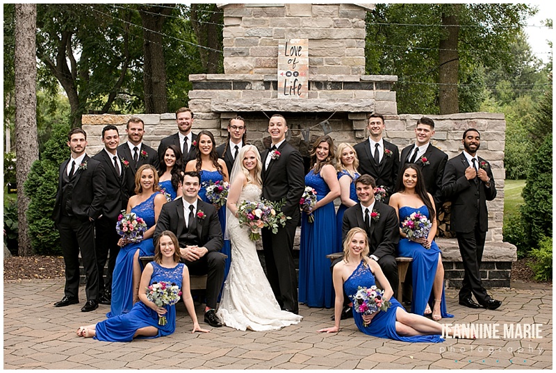 fireplace, royal blue bridesmaids dresses, black suits, wedding party, bride, groom, bridesmaids, groomsmen, line, The Gardens of Castle Rock, outdoor wedding, tent wedding, Northfield wedding, Minnesota wedding venues, unique wedding venues, garden wedding, woods wedding, Rustic Elegance, Studio B Floral, Mintahoe Catering, Sugar and Spice, We've Got It Covered, Adagio Djay Entertainment, SM Hair and Makeup, Justin Alexander, Bridal Accents Couture, David's Bridal, Northfield Lines, wedding inspiration, junior high sweethearts, Jeannine Marie Photography, Minnesota wedding photographer, Northfield wedding photographer, Gardens of Castle Rock wedding photographer, Saint Paul wedding photographer