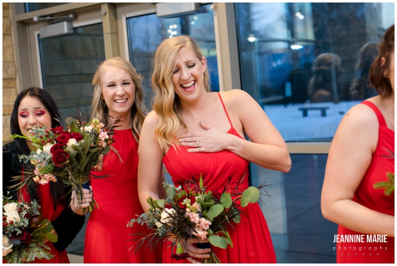 bridesmaids, laughing, wedding ceremony, red bridesmaid dress, winter wedding, Christmas wedding, red wedding, Eagan Community Center, Wilderland Floral, Makeup by Mindie, Hair by Theresa, Raffine Bridal, Buttercream, Green Mill Catering, Jeannine Marie Photography, Eagan Community Center wedding photographer, Minneapolis wedding photographer, Eagan wedding photographer, Saint Paul wedding photographer, Minnesota wedding photographer, winter wedding photography