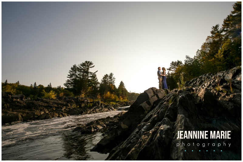 couple, standing, rocks, far shot, river, St. Louis River, Jay Cooke State Park, fall colors, Minnesota fall, fall engagement session, Northern Minnesota engagement session, Duluth engagement session, Jeannine Marie Photography, Northern Minnesota engagement photographer, Duluth engagement photographer, Minnesota engagement photographer, Twin Cities engagement photographer, Duluth wedding photographer, Minnesota wedding photographer, fall engagement portraits, nature engagement portraits, outdoor engagement portraits