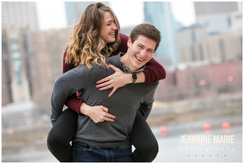 laughing, piggy back ride, Aster Cafe, Stone Arch Bridge, Mississippi River, engagement portraits, engagement session, engagement outfits, winter engagement session, Minneapolis engagement photographer, Saint Paul engagement photographer, Minneapolis wedding photographer, Saint Paul wedding photographer, Jeannine Marie Photography