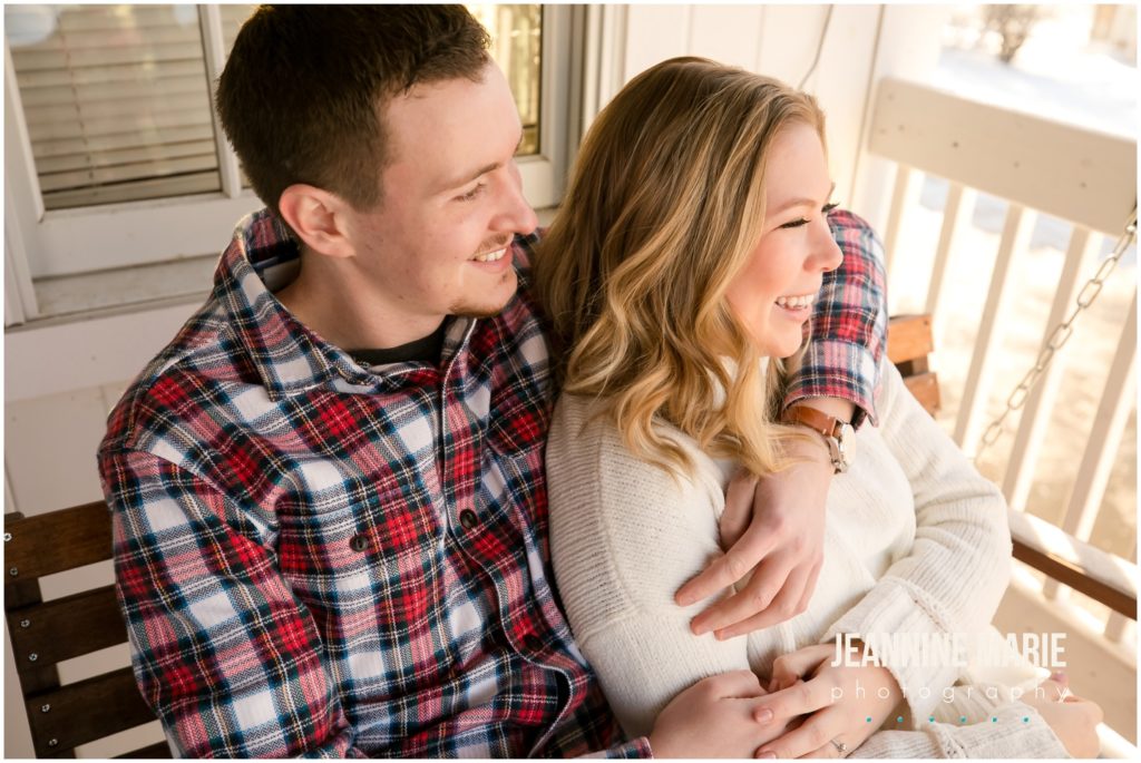 arms around her, porch swing, sun glow, couple portraits, winter engagement session, snowy engagement session, rustic engagement session, outdoor engagement session, Hope Glen Farm, Jeannine Marie Photography, Saint Paul engagement photographer, Minnesota engagement photographer