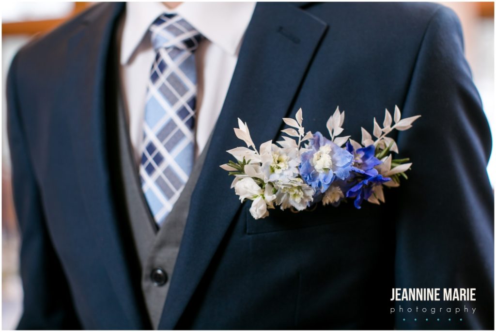 horizontal boutonniere, blue boutonniere, groom attire, pocket boutonniere, wedding details, wedding decor, wedding reception, centerpieces, floral design, backdrop, draping, chandeliers, dusty blue wedding, yellow wedding, winter wedding, spring wedding, Minnesota weddings, Majestic Oaks Golf Club, Studio B Floral, We've Got It Covered, 139 Hair by Heidi, Queen of Cakes, Milbern Clothing Co, Hunt Wright Design Co, Marie Wulff, Jeannine Marie Photography, Minnesota wedding photographer, Saint Paul wedding photographer, Minneapolis wedding photographer, Twin Cities wedding vendors, Minnesota wedding vendors, wedding reception, wedding ceremony, indoor wedding, wedding inspiration