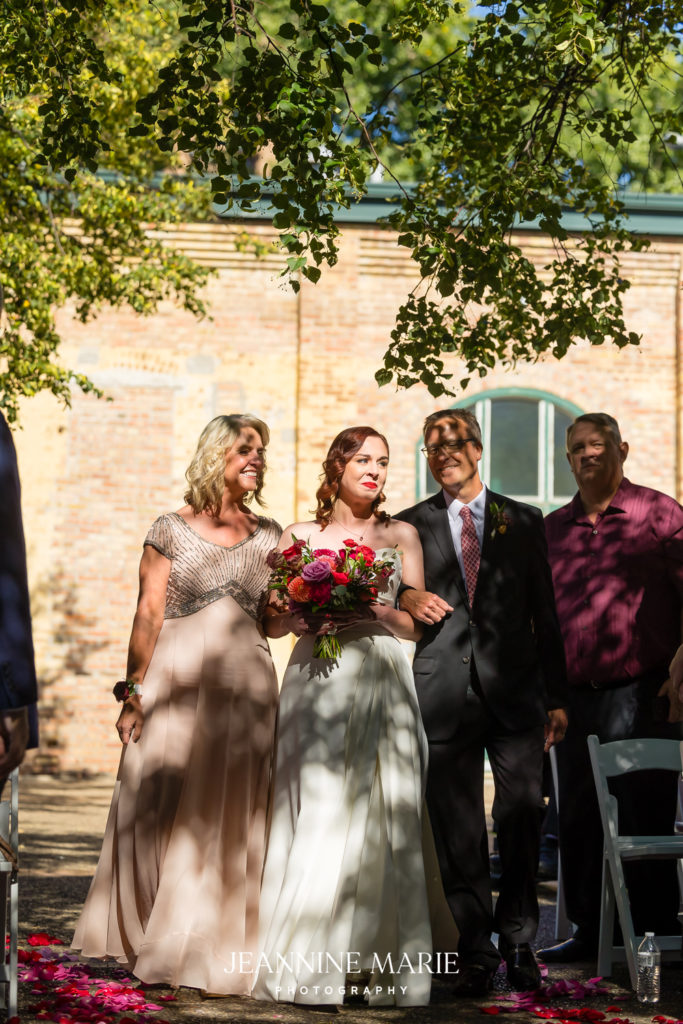 wedding processional of bride with mom and dad at Nicollet Island Pavilion in Minneapolis