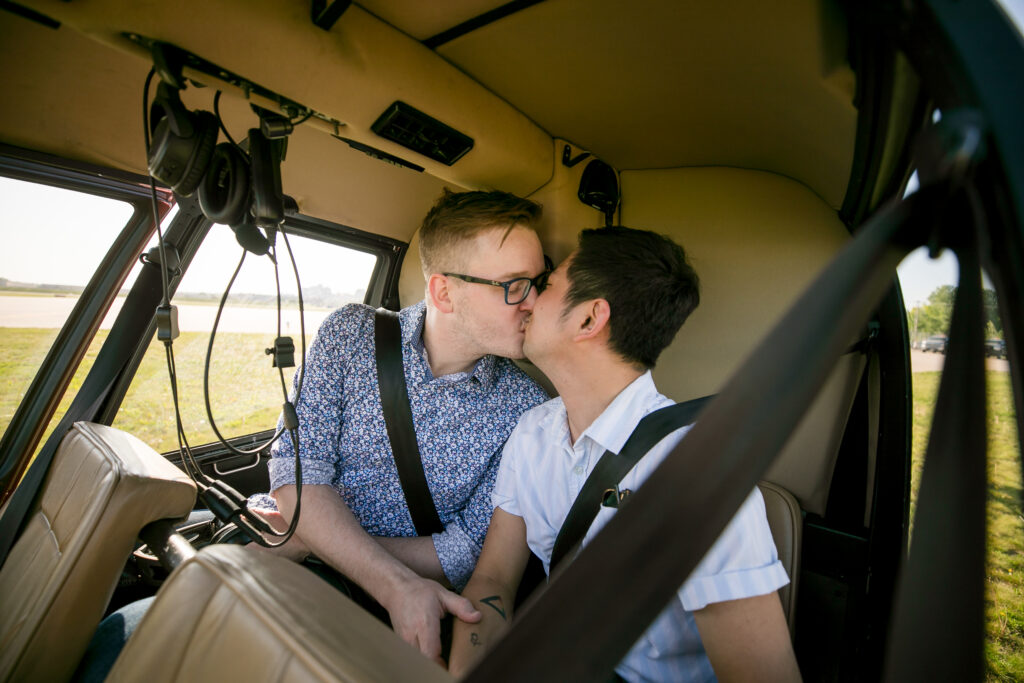 Gay couple kissing in a helicopter after their wedding proposal with Minnesota Helicopters in Saint Paul Minnesota.