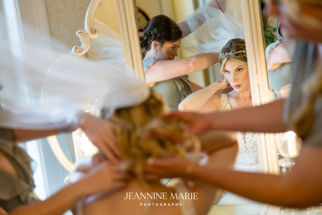 bride in getting ready suite at the saint paul college club adjusting her veil