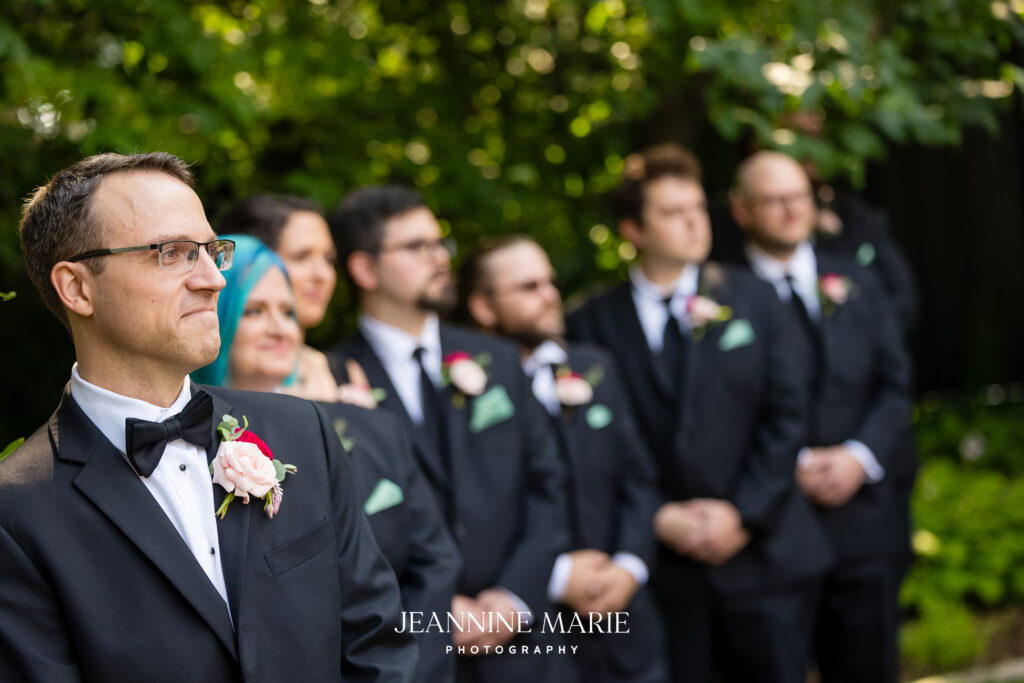 groom watching bride walk down the aisle at wedding